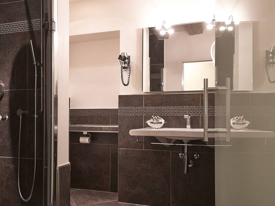 Une salle de bain moderne avec une douche à parois de verre, un meuble-lavabo avec un miroir et un évier.