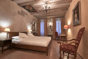 A bedroom with a wooden bed, two bedside tables, a chair, and a chandelier. - Hotel d'Allèves (Geneva)
