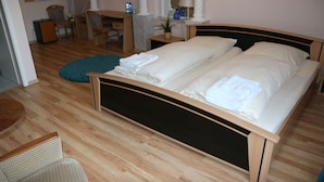 Un dormitorio con una cama de madera, un escritorio y una silla.