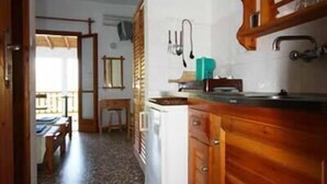 Una cocina con armarios de madera, un lavamanos y una encimera.
