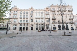 A large, historic building with multiple floors, large windows, and balconies.