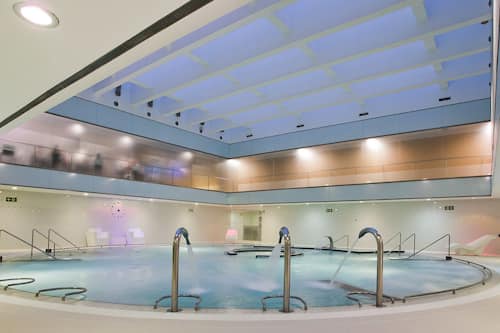 Una piscina cubierta, tumbonas