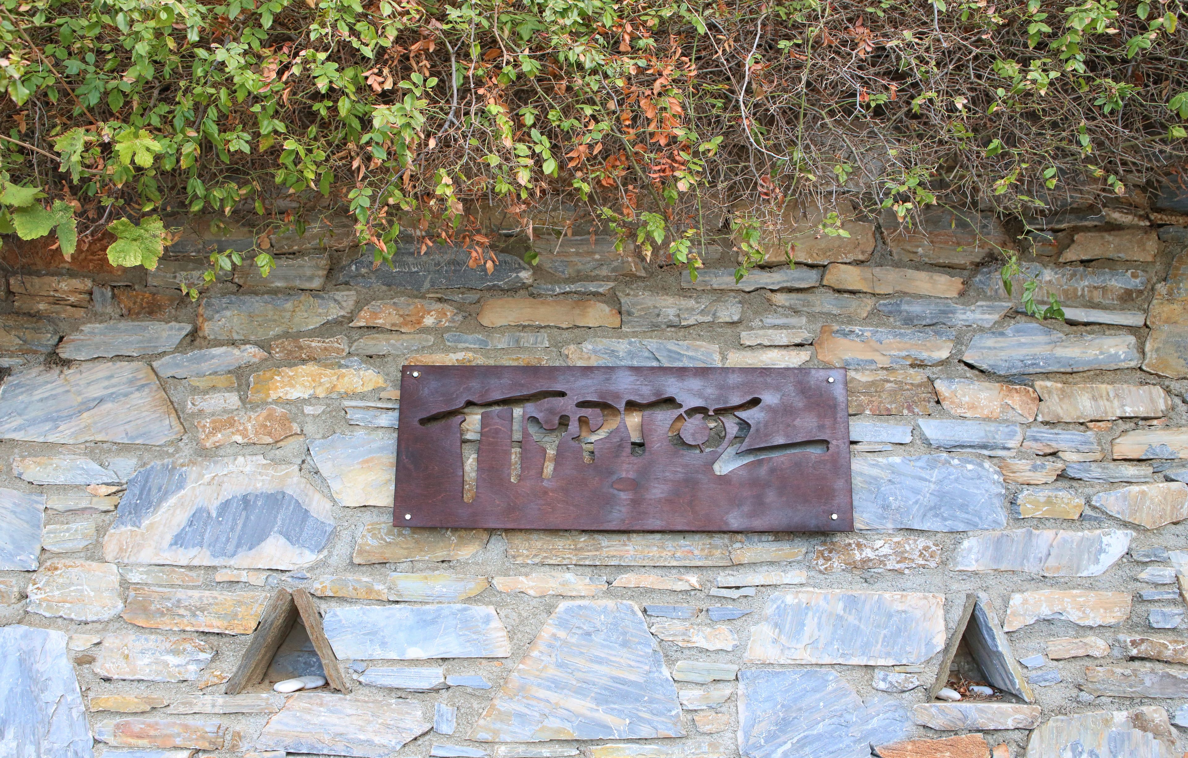 A stone wall with a metal plaque engraved with "Tipol."