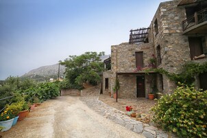 Un edificio de piedra con un camino de piedra que lleva a una puerta de madera.
