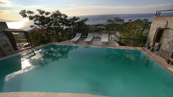 Una piscina al aire libre de temporada, sillones reclinables de piscina