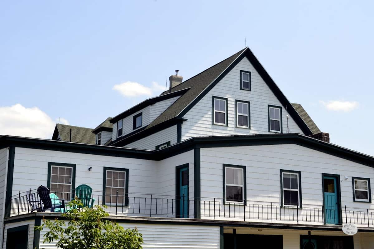 A two-story house with a balcony, a chimney, and a garage.