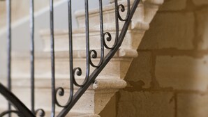 A close-up of a stone staircase with ornate metal railings. - Une Chambre chez Dupont (Bordeaux)