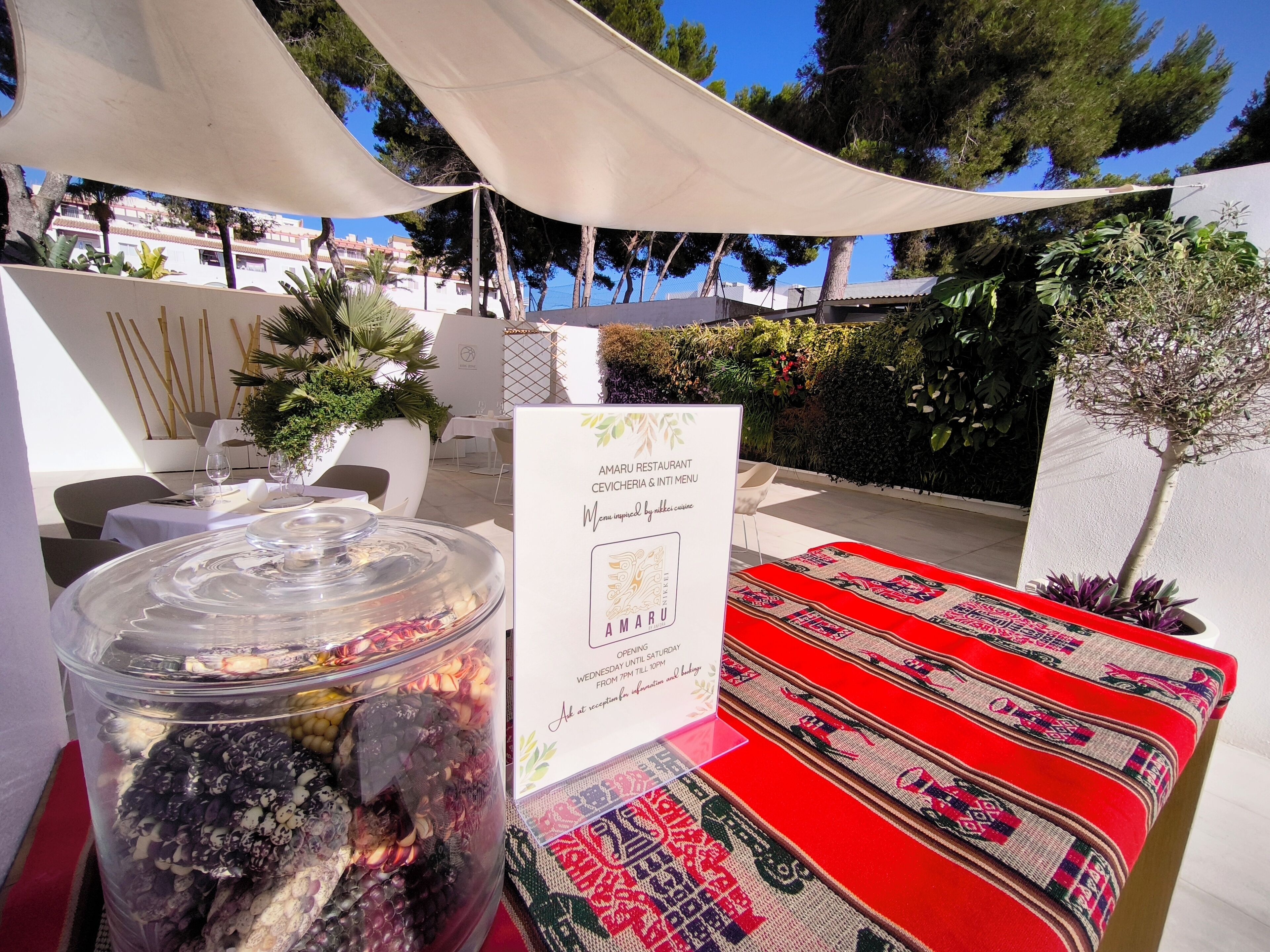 A table with a glass jar of mixed nuts and a sign for Amaru Restaurant.