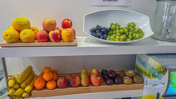A fruit display with oranges, apples, grapes, bananas, pears, and peaches.