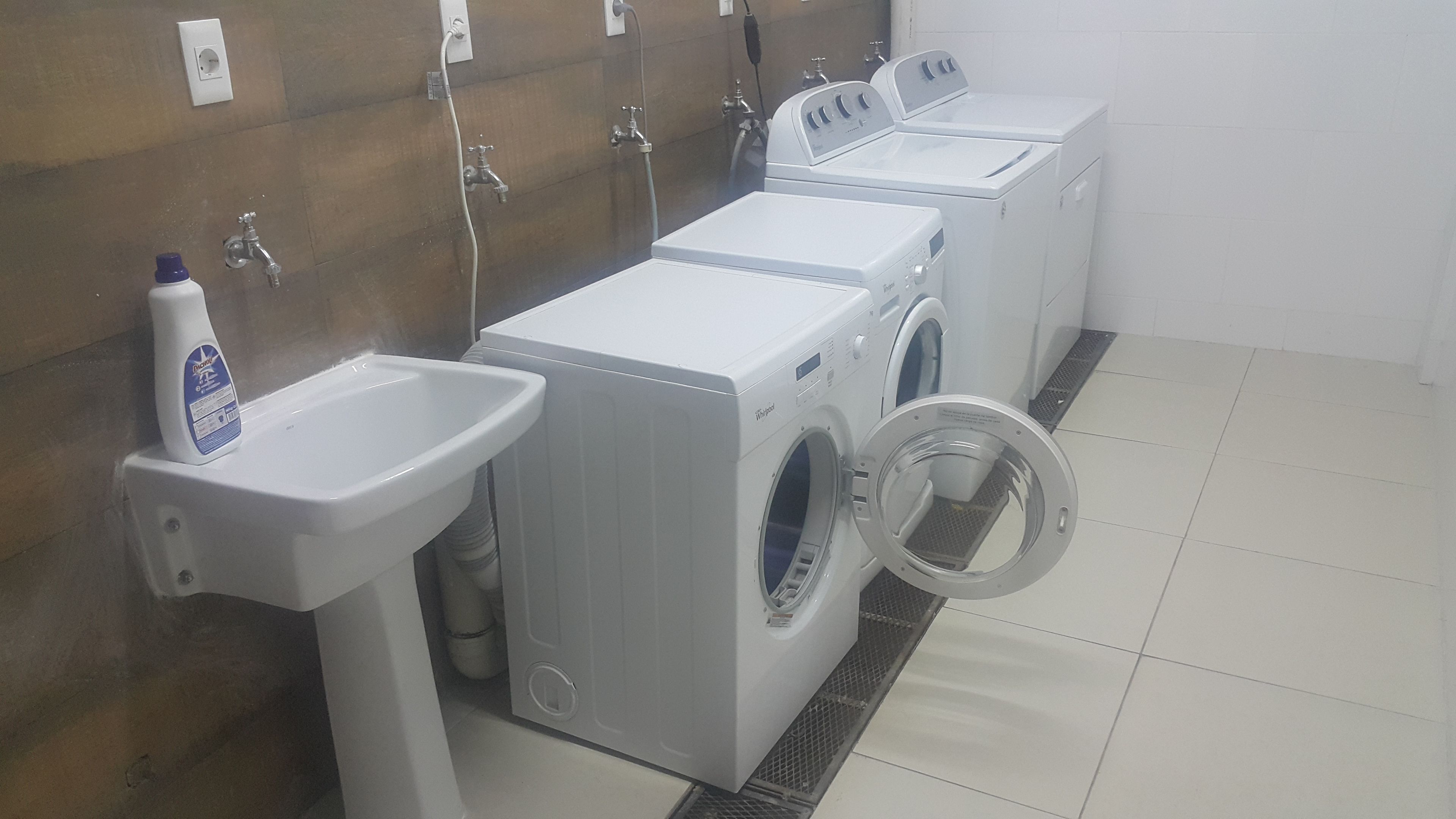 Eine Wäscherei mit drei Waschmaschinen und zwei Waschbecken.
