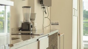 Eine moderne Küche mit eingebautem Mixer, einem Flachbildfernseher und einer Arbeitsplatte aus Granit.
