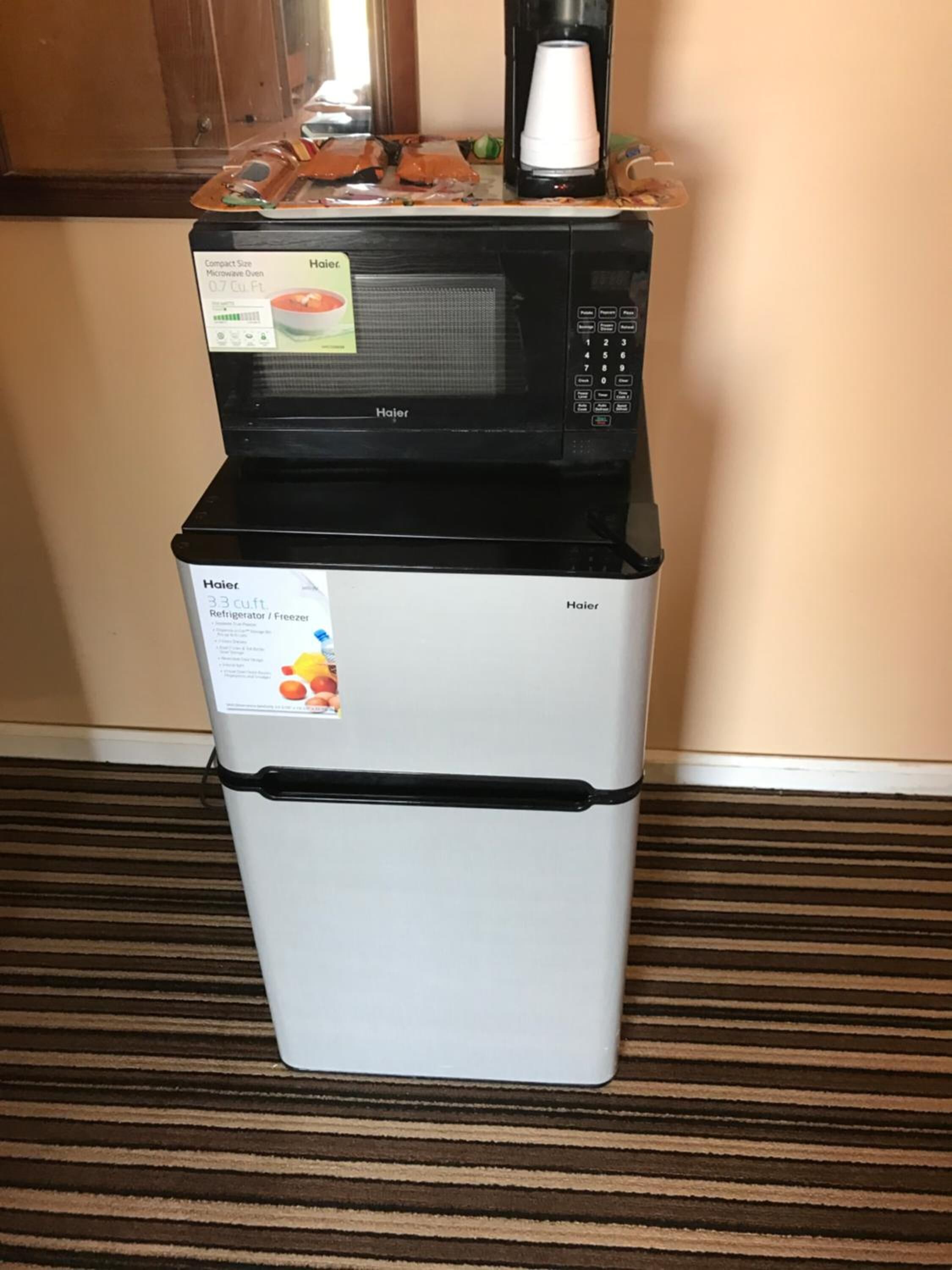 A compact Haier microwave oven and refrigerator combo unit in a kitchen area.