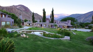 Um bairro residencial com casas modernas, um pequeno lago e cactos.