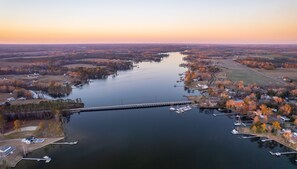 An aerial view of a river with a bridge, boats, and surrounding residential areas. - The Inn on Bath Creek (Bath)