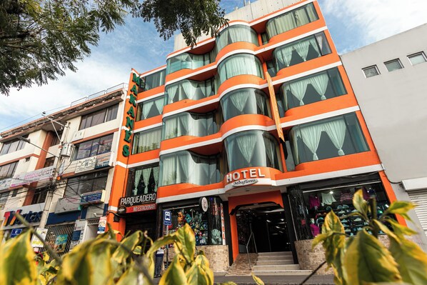 A multi-story hotel with a modern design, featuring balconies and large windows. - Hotel Miraflores (Ibarra)