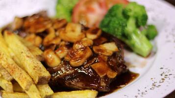 Un plato con bistec, papas fritas y brócoli.