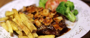 Un plato con bistec, papas fritas y brócoli.