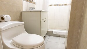 Een badkamer met toilet, kastruimte en douche.