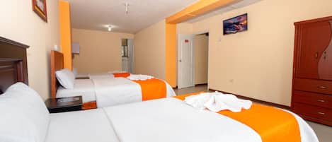 Et hotelværelse med to senge, et klædeskab og et billede på væggen.