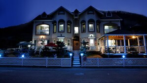 A large, two-story house with a symmetrical facade, multiple windows, and a covered porch area.
