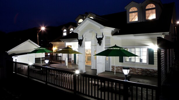 A building with a covered outdoor area, a gated entrance, and a brick facade.