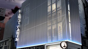 A modern building with a prominent 'FIRST CABIN' sign, featuring a vertical striped facade and illuminated signage. - First Cabin Nagasaki (Nagasaki)