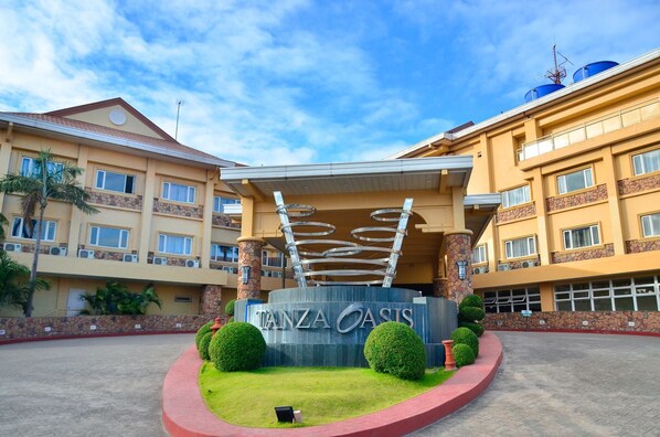A hotel entrance with a sign reading "TANZA OASIS" and a unique circular architectural feature above it. - Tanza Oasis Hotel and Resort (Tanza)