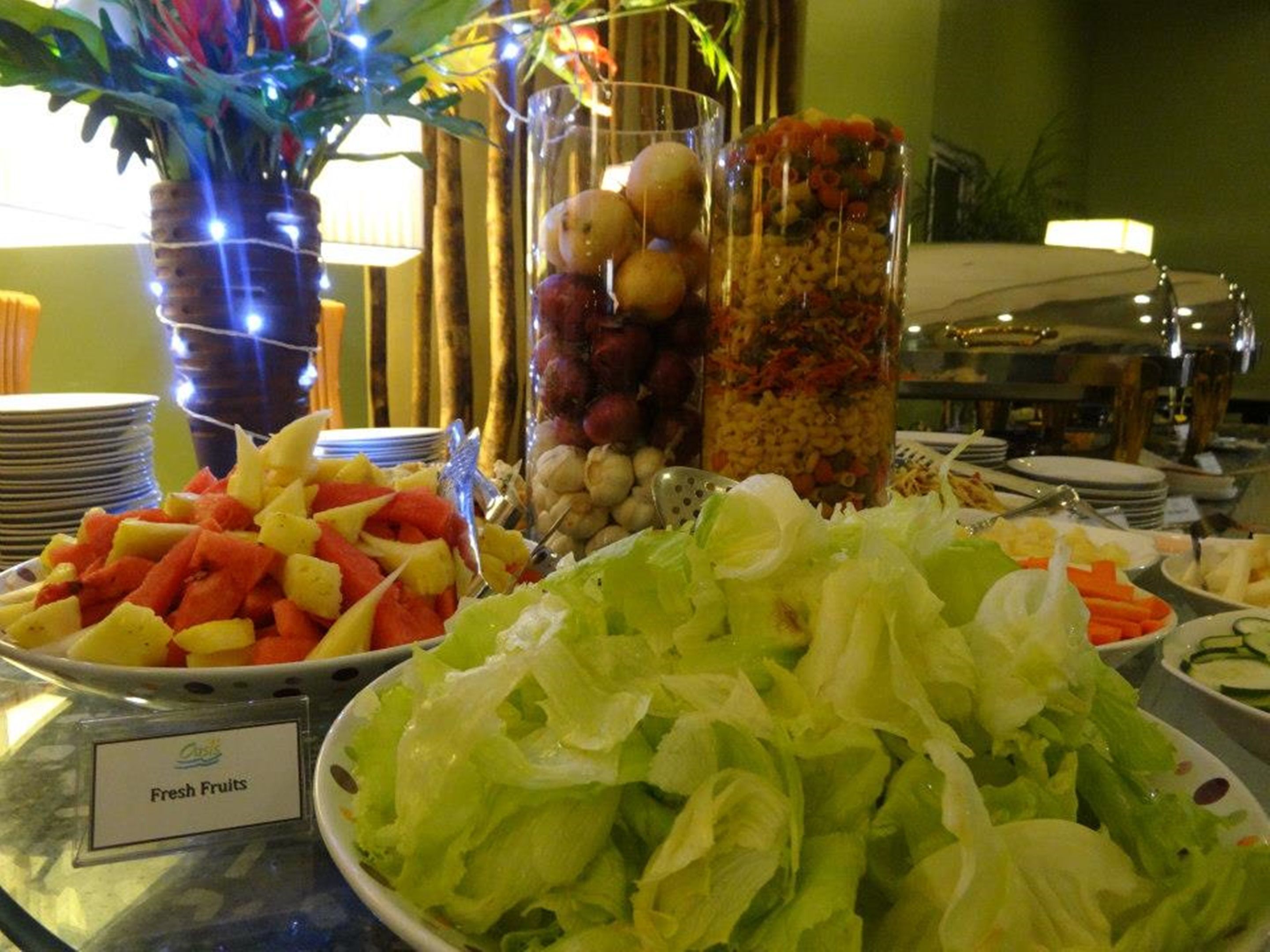 A buffet with fresh fruits, vegetables, and pasta salad.