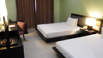 Een hotelkamer met twee bedden, een bureau, een stoel, een nachtkastje en een airconditioning.