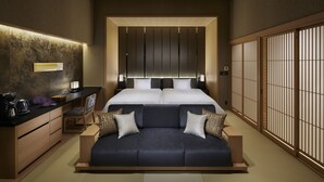 A modern bedroom with a large bed, a sofa, a desk, and a traditional sliding door. - Hatsuhana (Hakone)