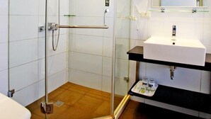 A modern bathroom with a glass-enclosed shower, a white sink, and a large mirror. - Yes Hotel (Taitung)