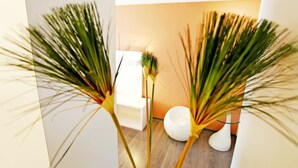 A modern interior with a wooden floor, white furniture, and green plants. - Yes Hotel (Taitung)