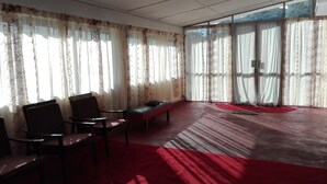 A room with a red carpet, a bench, and two chairs. - Kumara Sevana - The Family Cottage (Seetha Eliya)