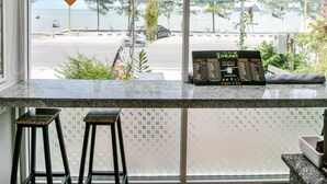 Eine Bar mit Blick auf die Straße und den Strand, ein Hinweisschild, dass sie geschlossen ist, und eine Speisekarte.