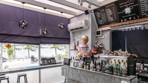 Ein Café mit Theke, Speisekarte und Sitzgelegenheit.