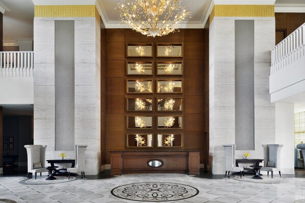A lobby with a grand chandelier, a marble floor, and a wall with multiple mirrors. - Sheraton Grand Palace Indore (Indore)
