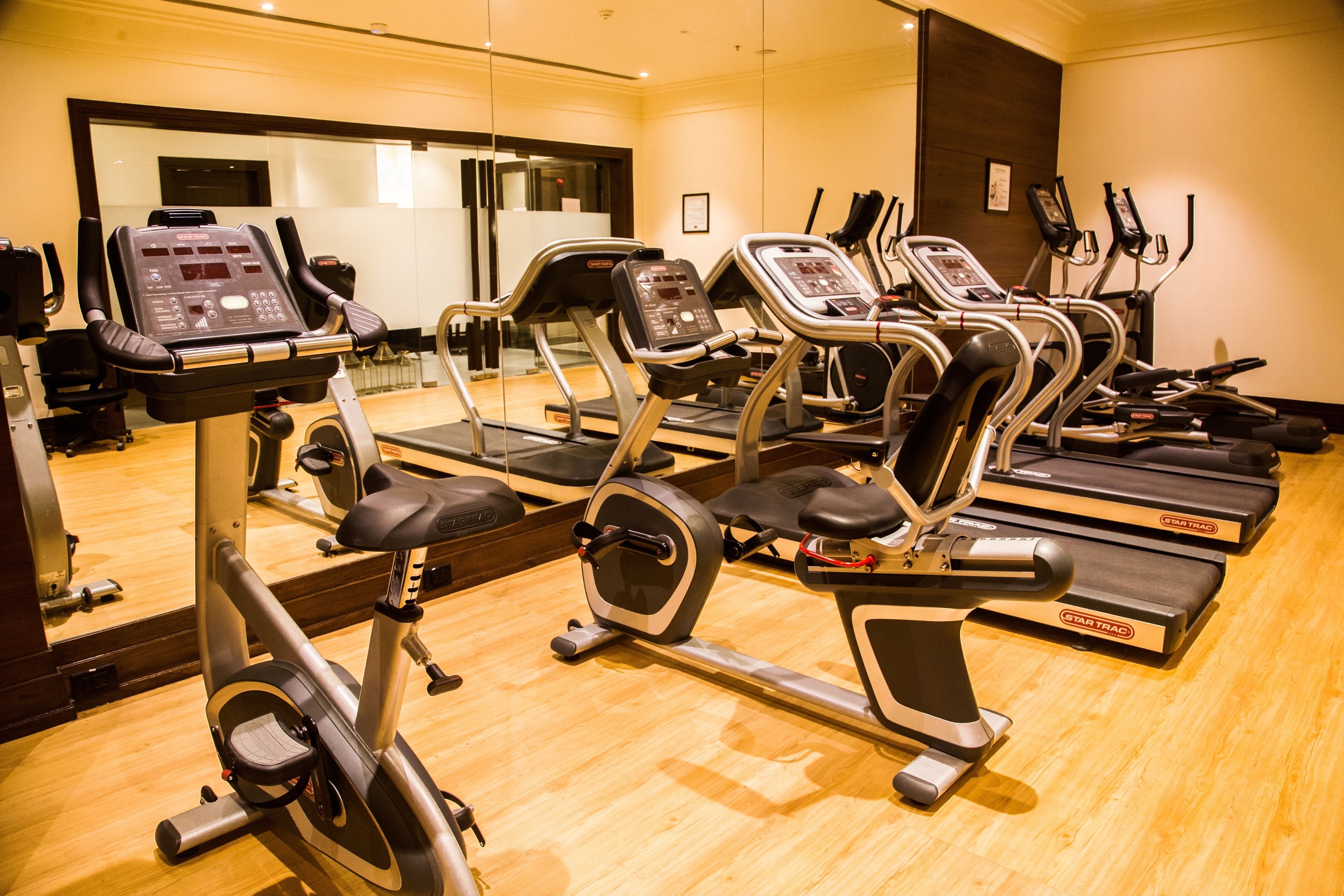 A gym with multiple treadmills and elliptical machines.