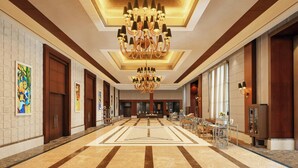A spacious lobby with a large chandelier, marble flooring, and a reception desk. - Sheraton Grand Palace Indore (Indore)