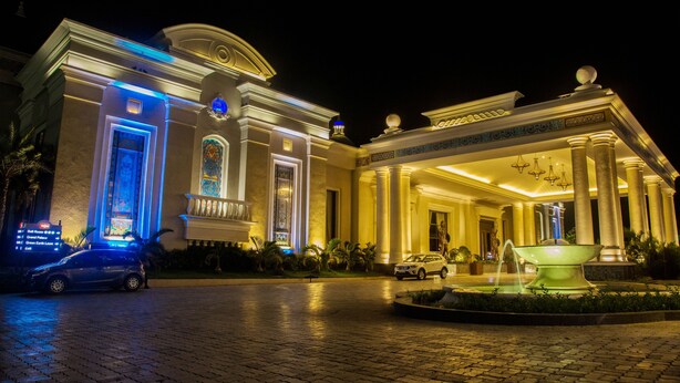 A grand building with a fountain in front, a driveway, and a car parked on the side. - Sheraton Grand Palace Indore (Indore)