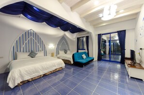 A bedroom with two beds, a blue sofa, and a desk with a computer. - C'est La Vie Villa (Hengchun)