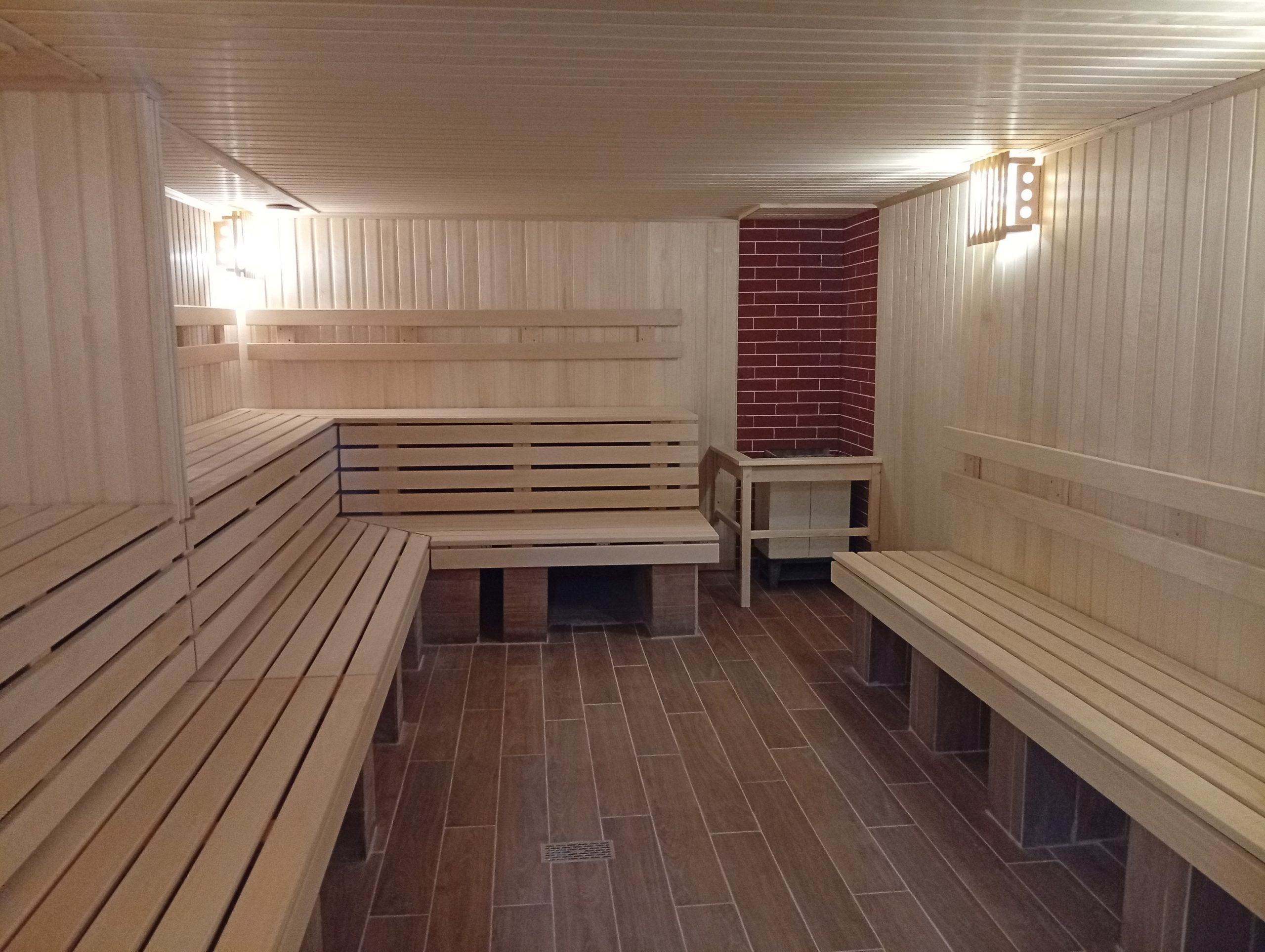 Una sauna con bancos de madera y suelo de baldosas.