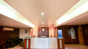 Welcome to our reception area, featuring a central desk, comfortable sofa, and framed artwork.