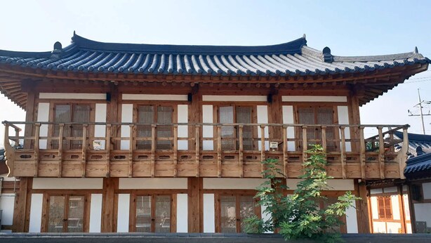 A traditional wooden building with a tiled roof and multiple windows. - Lee Ga Hanok (Jeonju)