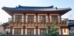 A traditional wooden building with a tiled roof and multiple windows. - Lee Ga Hanok (Jeonju)