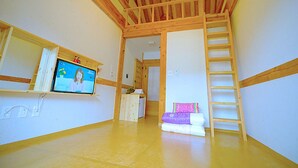 A room with a wooden ceiling, a TV on a shelf, a bed with pillows, and a ladder. - Lee Ga Hanok (Jeonju)
