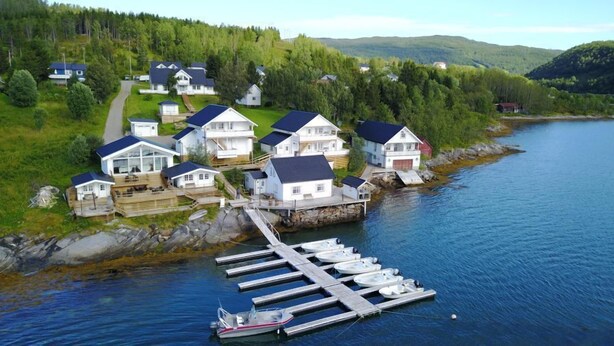 A coastal village with houses connected by a dock to a body of water. - Furoy Hotel Apartments and Boating (Sorreisa)