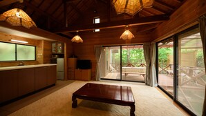 A wooden interior with a kitchen, dining area, and large sliding glass doors to an outdoor deck.