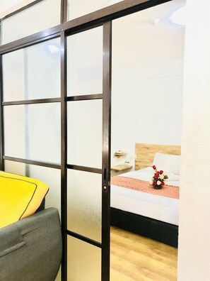 A room with a bed, a bedside table, a lamp, and a small wooden shelf. -  AM Transit Inn Kuala Terengganu (Kuala Terengganu)