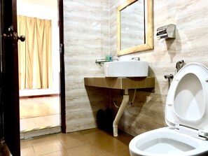 Bathroom features a vanity, sink, and toilet, with a mirror above the sink.