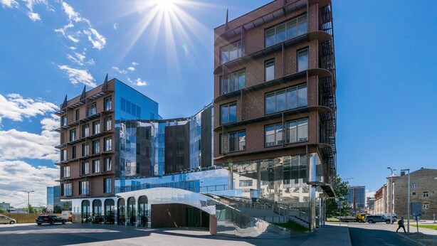 Un edifici modern amb façana de vidre i entrada corbada.